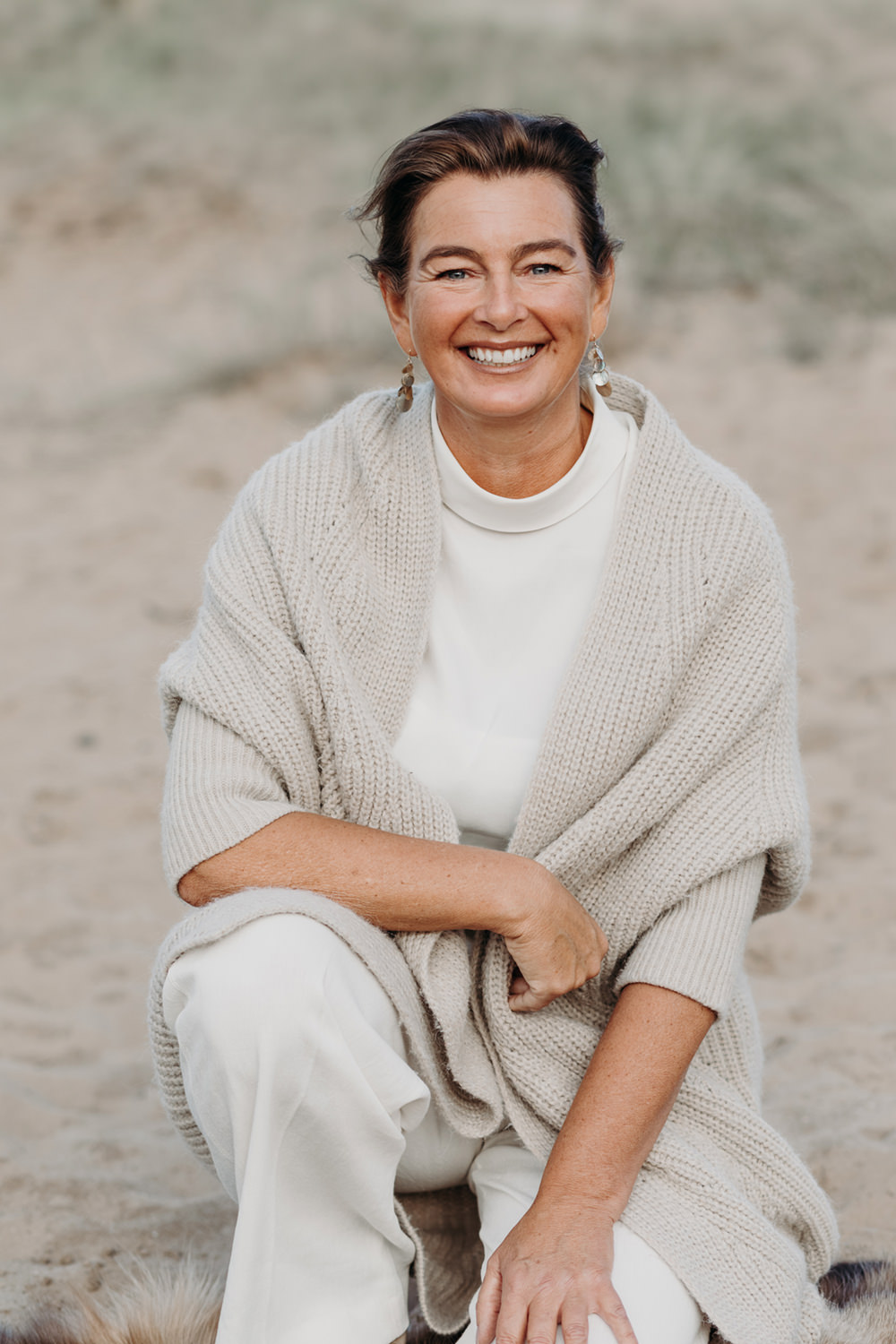 Lifestyle portret van vrouw in witte kleren in de duinen voor personal branding