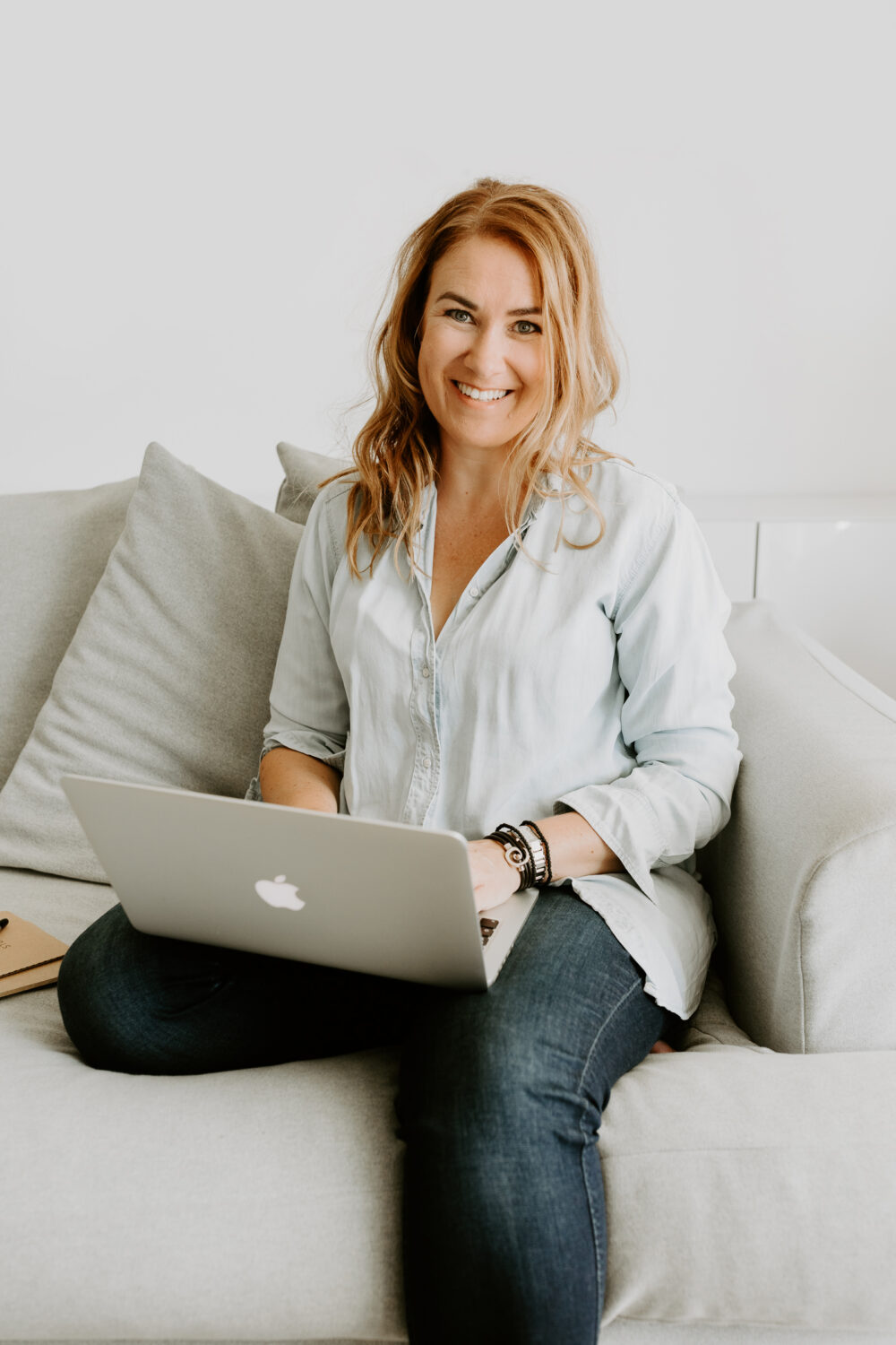 Lifestyle portret van glimlachende vrouw met lang haar en haar laptop voor personal branding