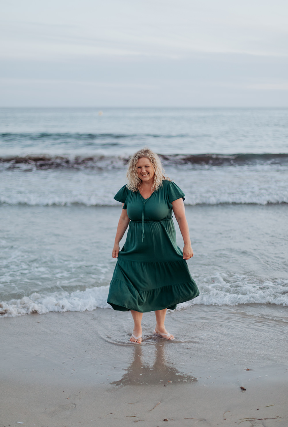 lifestyle fotograaf marianne Hope in een groene jurk aan het dansen in het water voor spontane foto's