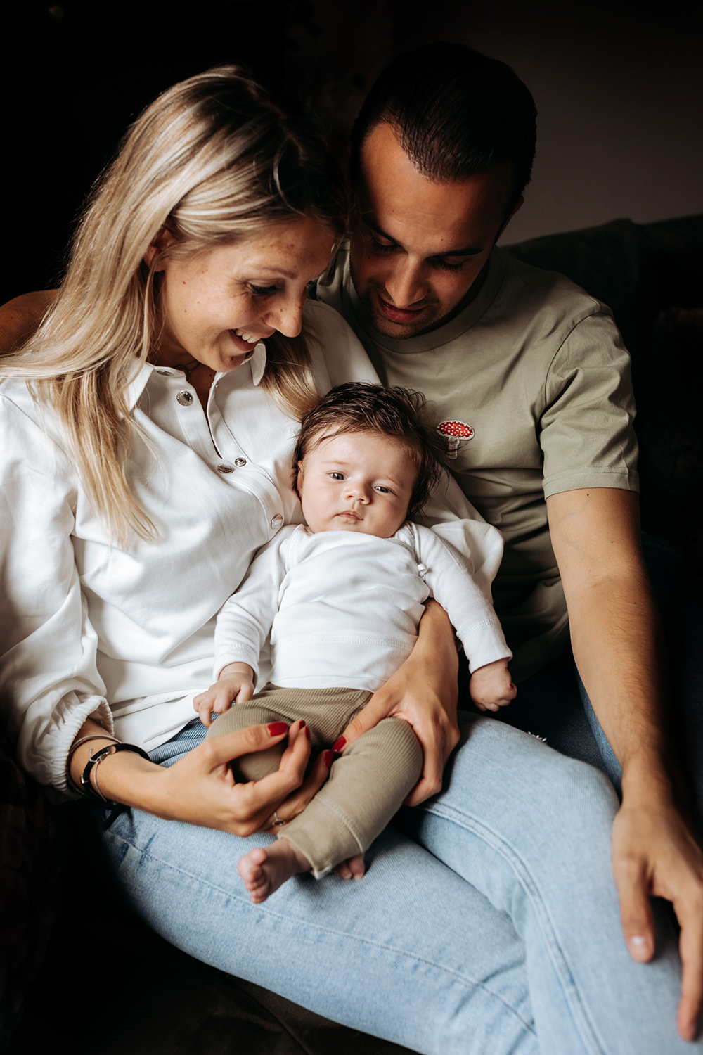 foto van een gezin met een baby tijdens een gezinsfotoshoot aan huis