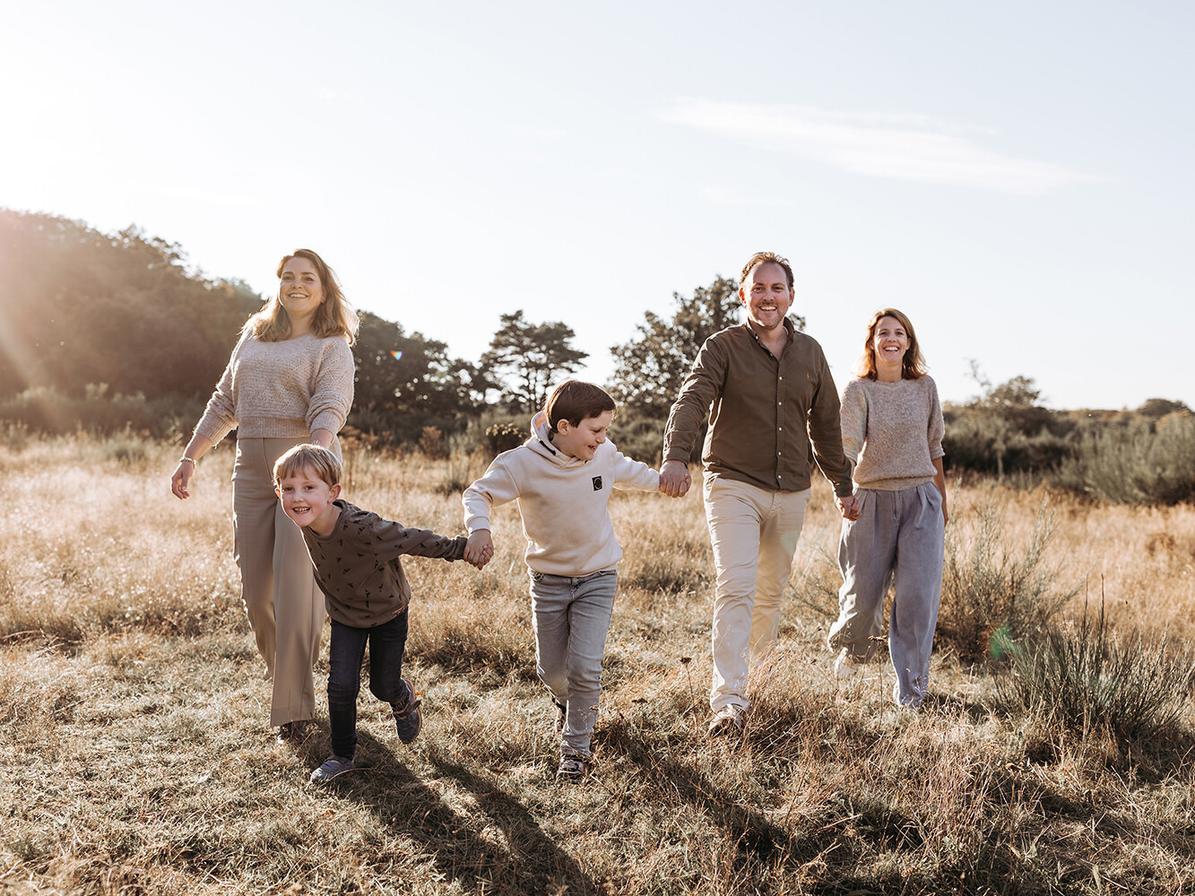 Spontane, leuke foto van een gezin tijdens een gezinsfotoshoot buiten in golden hour licht