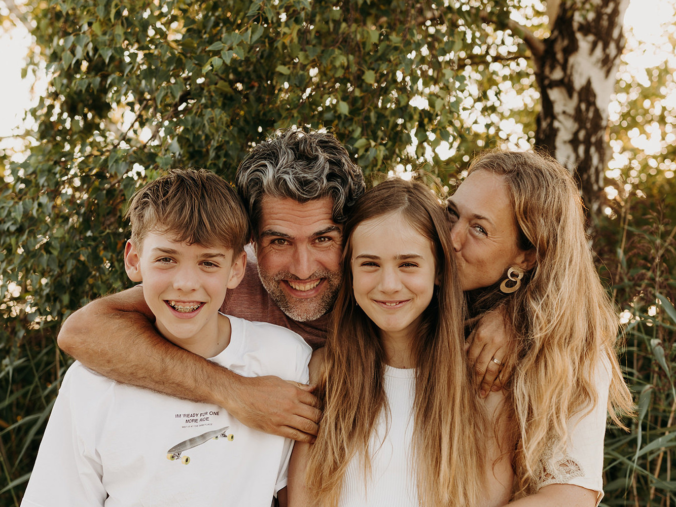 foto van een gezin van vier met teenagers tijdens een gezinsfotoshoot buiten