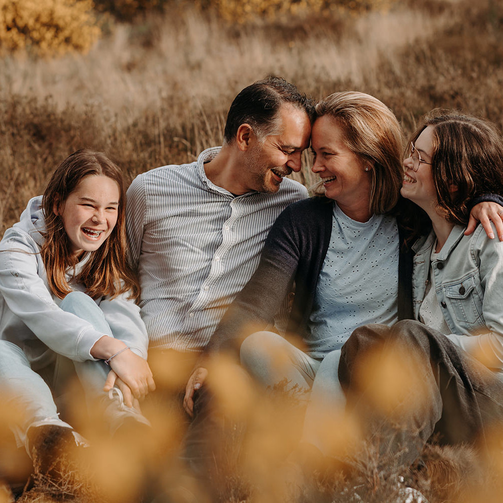 foto van een gezin van vier met teenagers tijdens een gezinsfotoshoot buiten