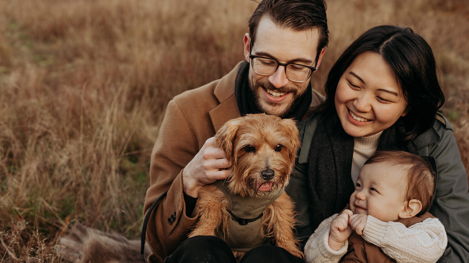 foto van een gezin van drie en een hond tijdens een gezinsfotoshoot buiten