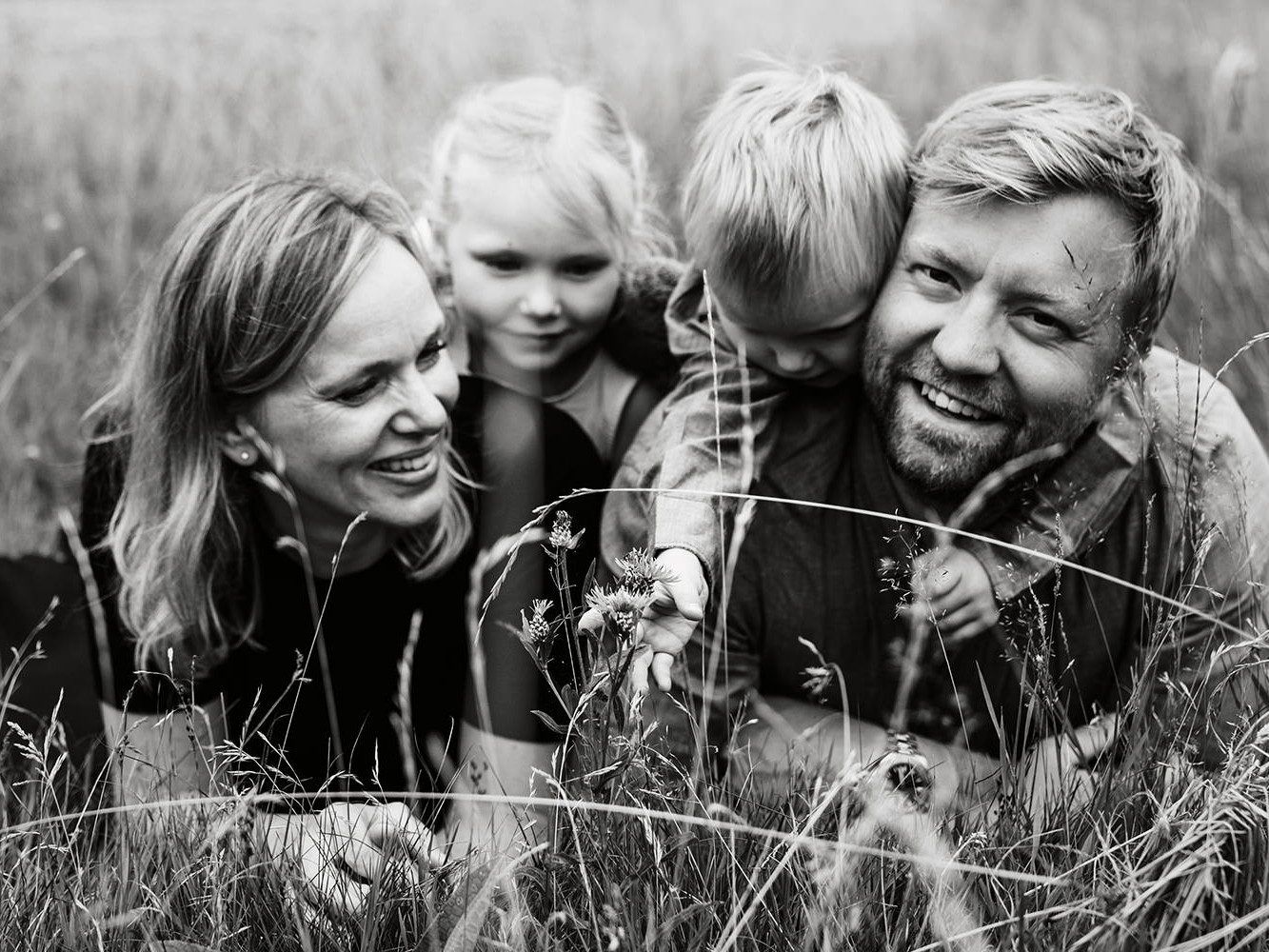 zwartwit foto van een gezin van vier tijdens een gezinsfotoshoot buiten