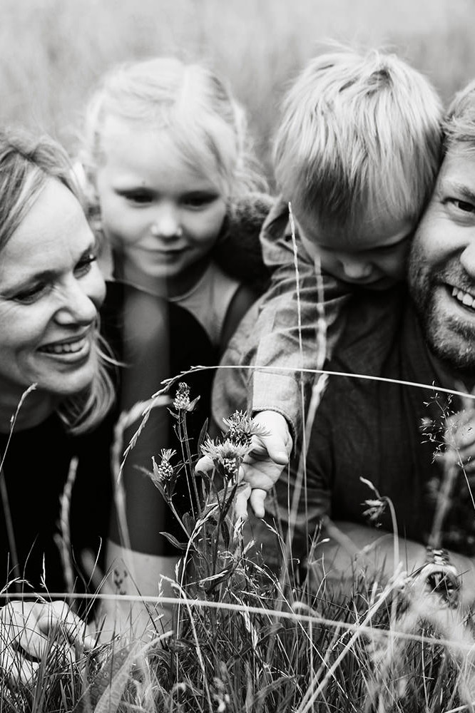 zwartwit foto van een gezin van vier tijdens een gezinsfotoshoot buiten