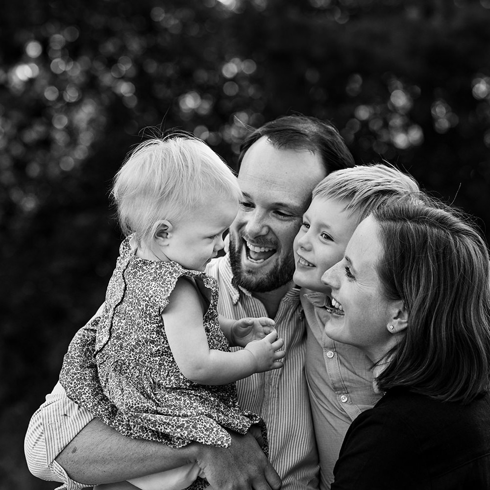 zwartwit foto van een gezin van vier tijdens een gezinsfotoshoot buiten