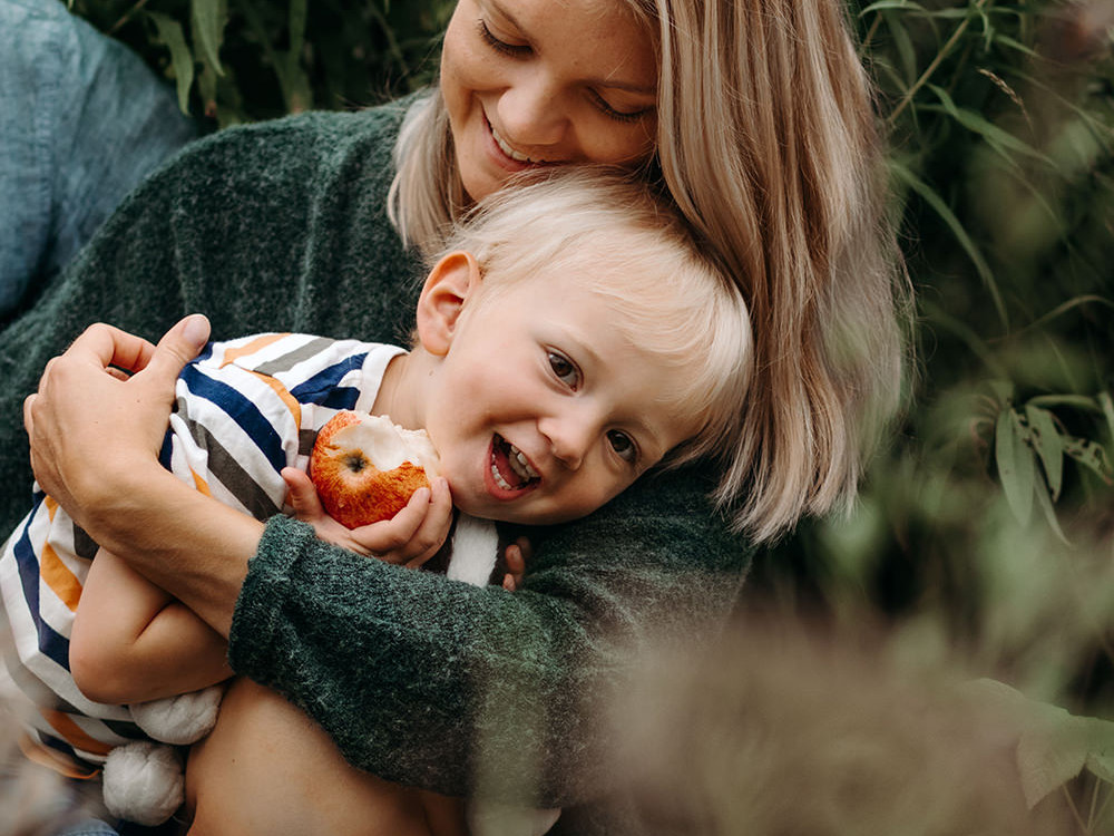 liefdevolle foto van een moeder met haar zoon tijdens een gezinsfotoshoot buiten