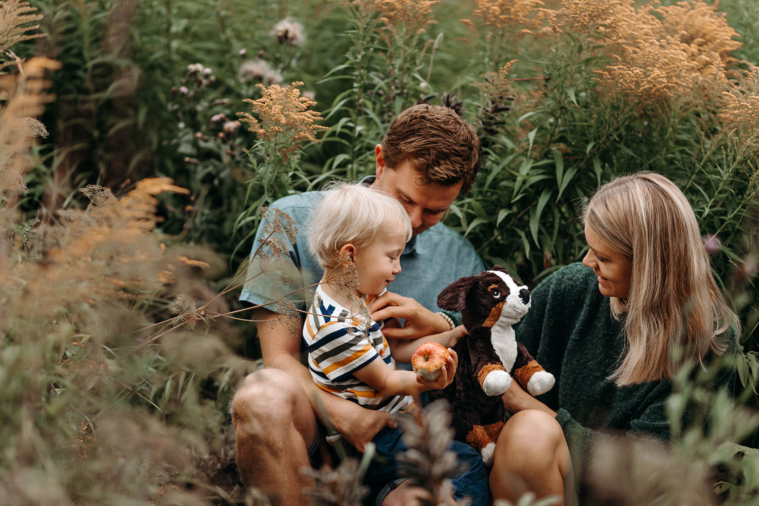 foto van een gezin van drie en een hond tijdens een gezinsfotoshoot buiten