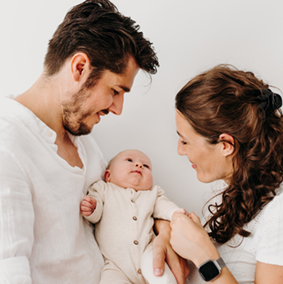 foto van een gezin met een baby tijdens een gezinsfotoshoot aan huis