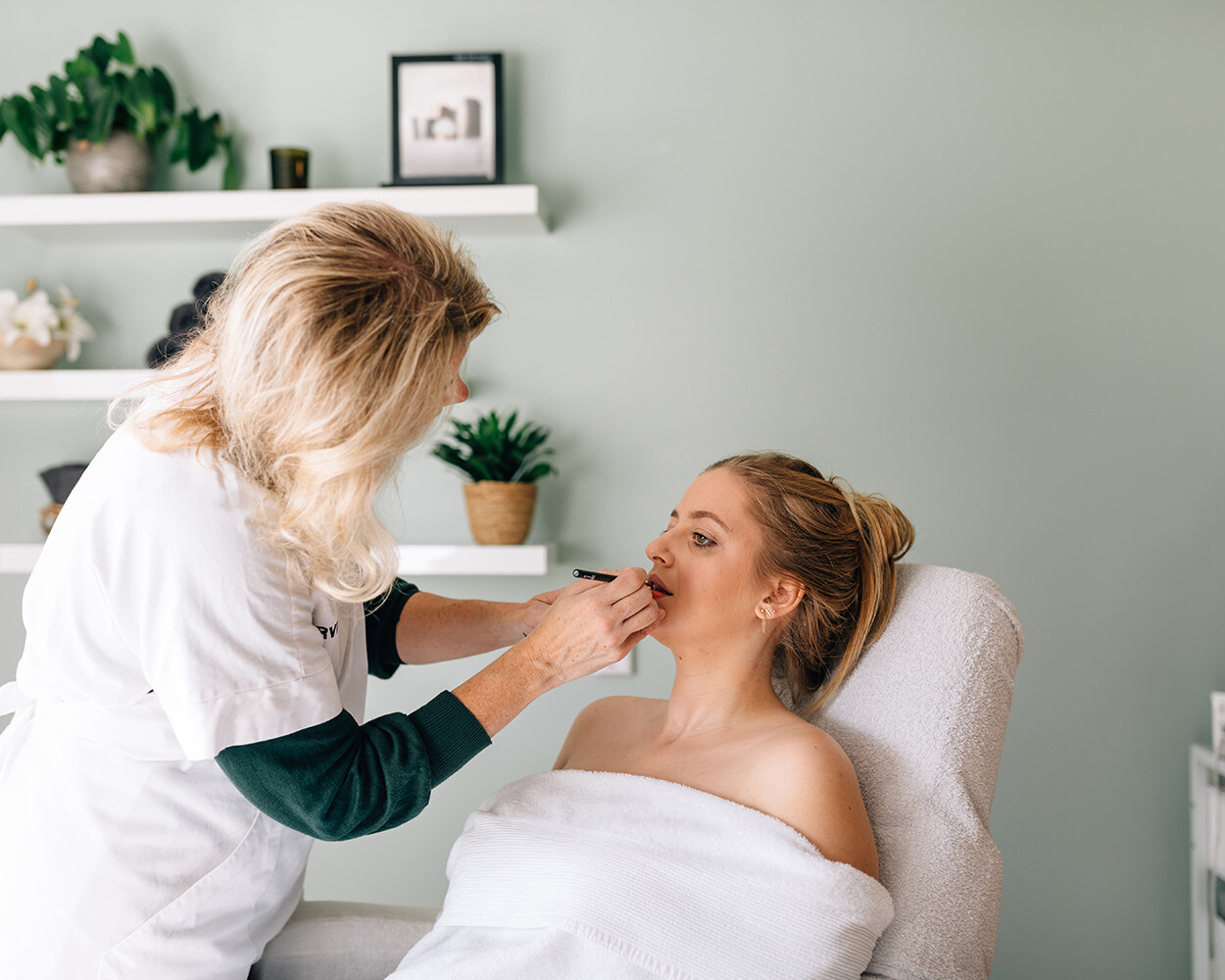 Personal branding foto van een schoonheidsspecialiste die de make-up van aan een vrouw