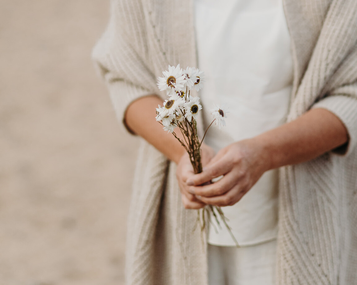 Lifestyle foto van een vrouw die gedroogde bloemen vasthoudt voor een personal branding fotoshoot