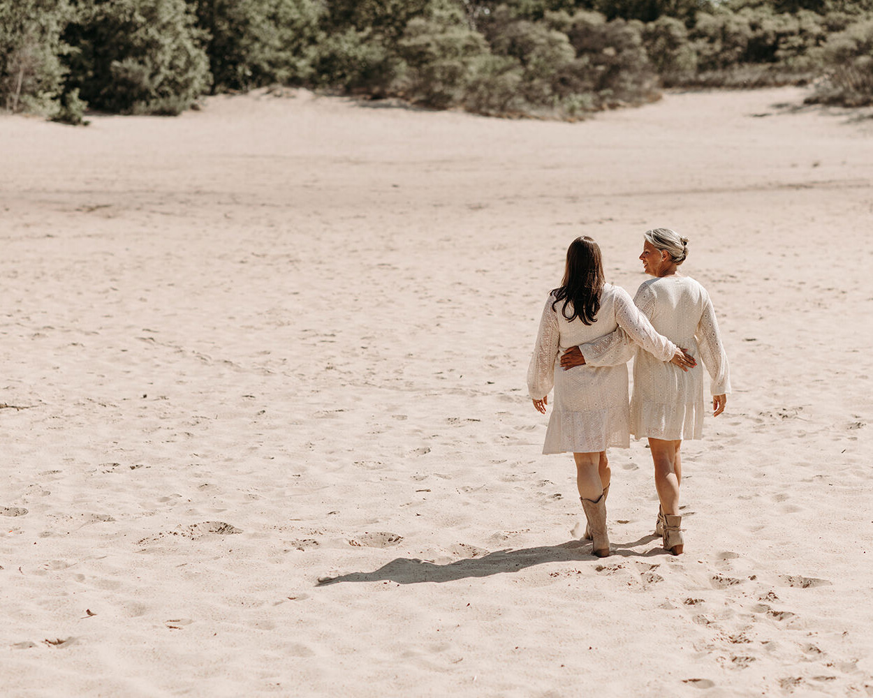 Lifestyle foto van 2 vrouwen in witte jurken in de duinen voor een personal branding fotoshoot