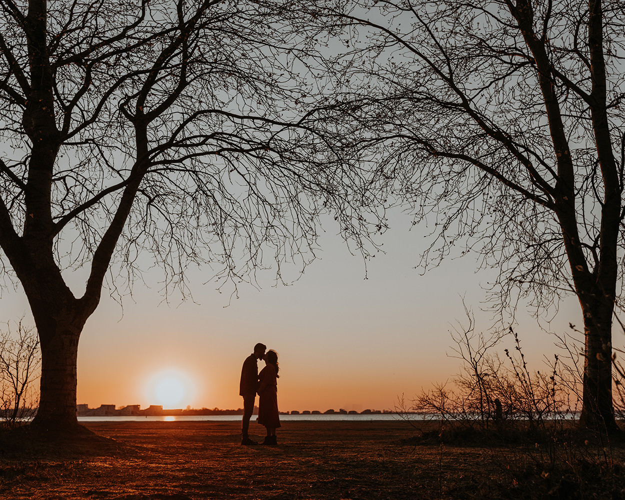 golden hour silhouetten foto van een jong verliefd stel tijdens een zwangerschapsshoot op het strand in Blaricum tijdens de zonsondergang