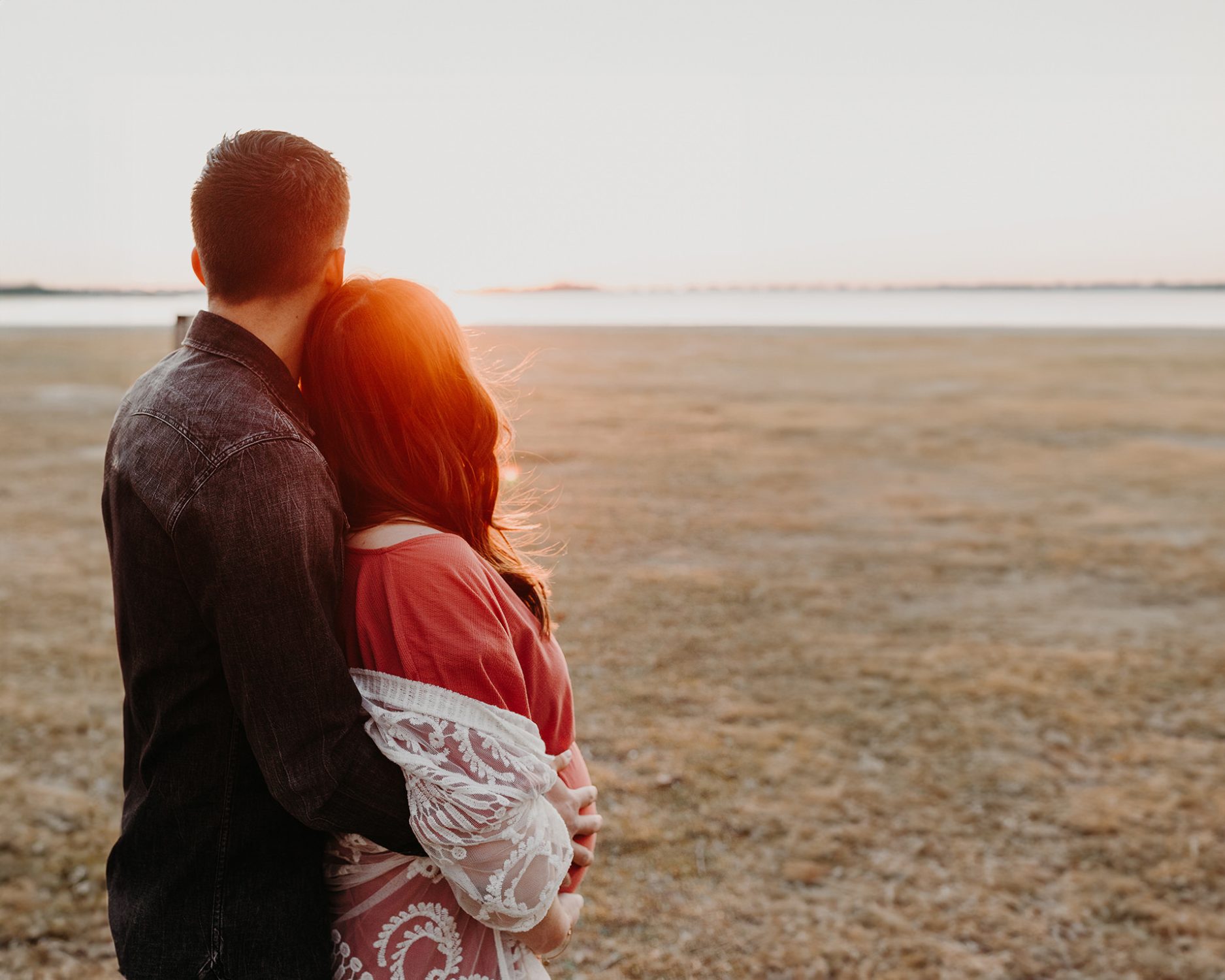 golden hour foto van een jong verliefd stel tijdens een zwangerschapsshoot op het strand in Blaricum