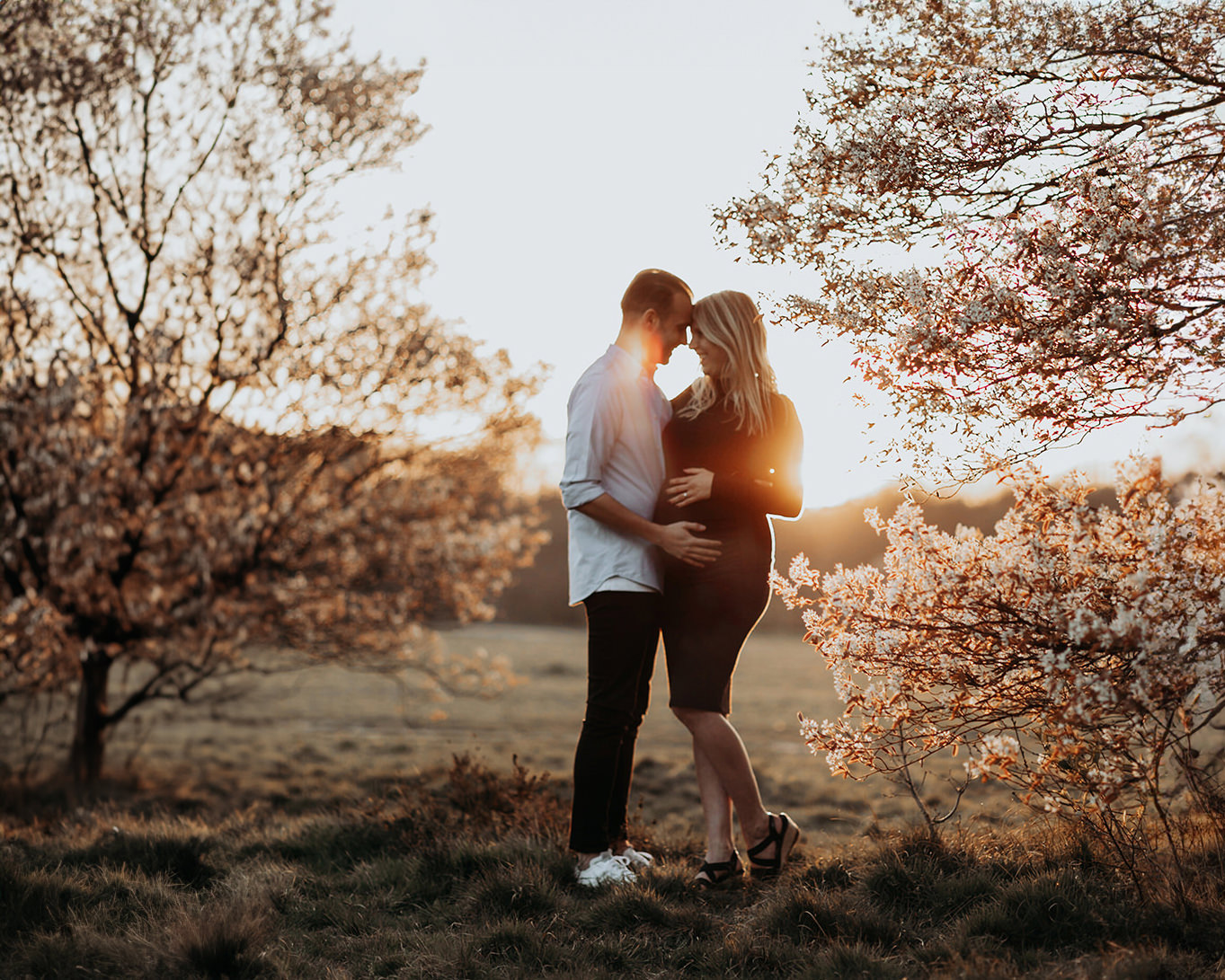 warme, zonnige foto van een jong verliefd stel tijdens een zwangerschapsshoot