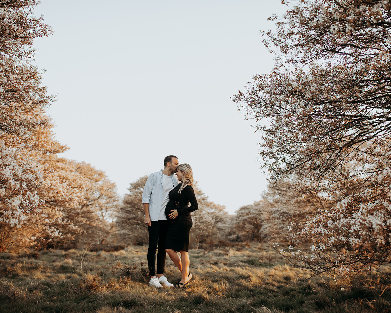 warme foto van een jong verliefd stel tijdens een zwangerschapsshoot in lente