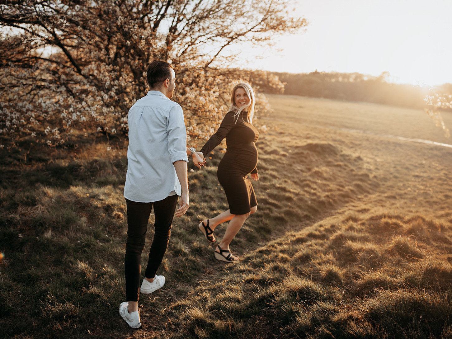 warme, zonnige foto van een jong verliefd stel tijdens een zwangerschapsshoot