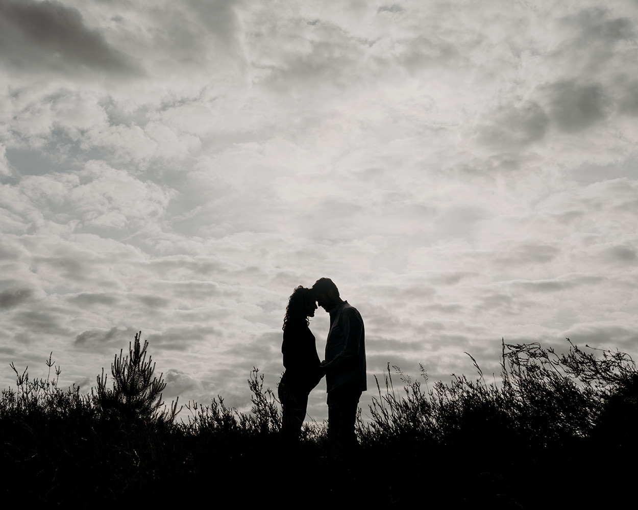 silhouetten foto van een jong verliefd stel tijdens een zwangerschapsshoot op de hei in Blaricum